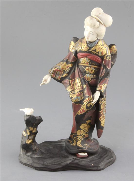 A Japanese ivory and lacquered wood okimono of a bijin feeding a bird, early 20th century, height 27cm